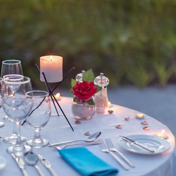 In-villa dining experience with a romantic candlelight setup