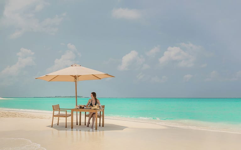 A guest enjoying the private sandbank picnic with a beautiful ocean view